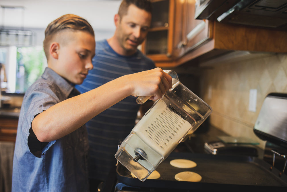 Father making grain free pancakes with his son